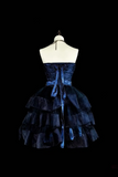 Navy blue strapless dress with ruffled layers on a mannequin against a black background