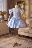 Light blue dress on a mannequin in a room with a couch and decor.