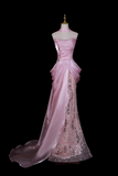 Pink evening gown on a mannequin against a black background