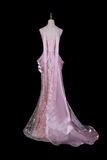 Pink evening gown on a mannequin against a black background