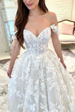 Woman wearing a white lace dress with floral details indoors.