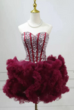 Red and silver beaded dress with a fluffy purple skirt on a mannequin against a white background