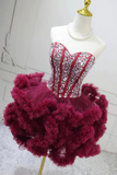 Red evening gown with floral embellishments on a mannequin against a white background