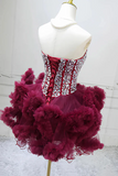 Red and white dress with ruffled skirt on a mannequin against a plain background