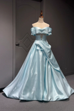 Light blue evening gown on a mannequin against a dark background