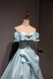 Light blue off-shoulder gown on a mannequin against a dark background