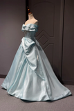 Light blue satin gown on a mannequin against a dark background