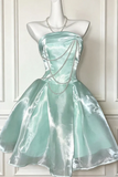 Mint green strapless dress with a necklace on a mannequin against a white paneled wall.