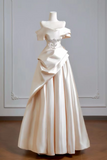 Elegant white evening gown on a mannequin against a neutral background