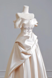 White evening gown with floral details on a mannequin against a plain background
