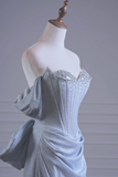 Silver evening gown on a mannequin against a gray background