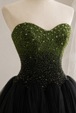 A strapless sweetheart ball gown displayed on a cream dress form. The bodice features a dense, sparkling green and black beaded sequin pattern, while the skirt is a voluminous black tulle.