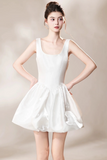 A woman modeling a white sleeveless mini dress with a square neckline and a flared skirt, posed against a neutral beige studio background.