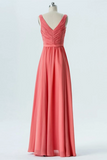 A floor-length coral pink formal gown displayed on a mannequin against a plain light gray studio background. The dress has a ruched V-neck bodice, a defined waistband, and a flowing skirt.