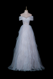 An off-the-shoulder white tulle wedding gown with a beaded bodice and a full layered skirt, displayed on a mannequin against a solid black background.