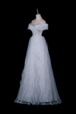 A white off-the-shoulder tulle gown displayed on a mannequin against a solid black background.