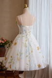 White dress with floral patterns on a mannequin against a curtain backdrop