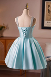 A light blue satin short dress with a corset-style lace-up back and silver patterned shoulder straps, displayed on a cream mannequin in an indoor room setting.