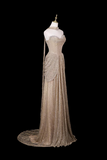 A floor-length champagne beige evening gown with a sweetheart neckline, strapless bodice, draped side detail, and a long train, displayed on a mannequin against a solid black background.