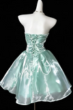 A strapless mint green taffeta mini dress with a corseted waist and lace-up back, displayed on a white mannequin against a solid black background.
