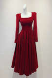 A long-sleeved red velvet dress with a square neckline and flared skirt, displayed on a white mannequin against a plain light background.