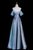 A shimmering off-the-shoulder A-line gown in metallic light blue and silver, displayed on a white mannequin against a solid black background.