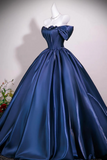 A royal blue satin off-the-shoulder ball gown displayed on a white mannequin, featuring a structured corset bodice, large bow details on the shoulders, and a voluminous skirt.