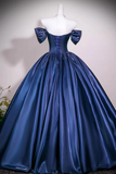 A royal blue satin ball gown with an off-the-shoulder design, featuring large bow details on the shoulders and a lace-up corset bodice, displayed on a white mannequin.