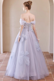 A woman wearing a lavender off-the-shoulder ball gown with a lace-up back and sheer sleeves, photographed from behind in an indoor architectural setting with beige walls and tiled flooring.