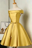 A golden yellow off-the-shoulder satin dress displayed on a mannequin, featuring a fitted bodice, a matching waist tie, and a flared skirt.